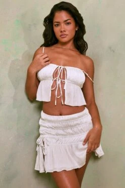 Shirred Tie Up Front Crop Top In White 17 Shirred Tie Up Front Crop Top In White -Sway Line Zone 7195 7206 3 White Tie Up Front Crop Top Crinkle Tie Up Asymmetrical Shirring Mini Skirt